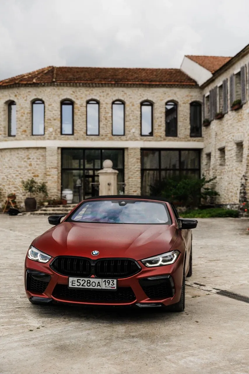 Красный BMW у каменного здания